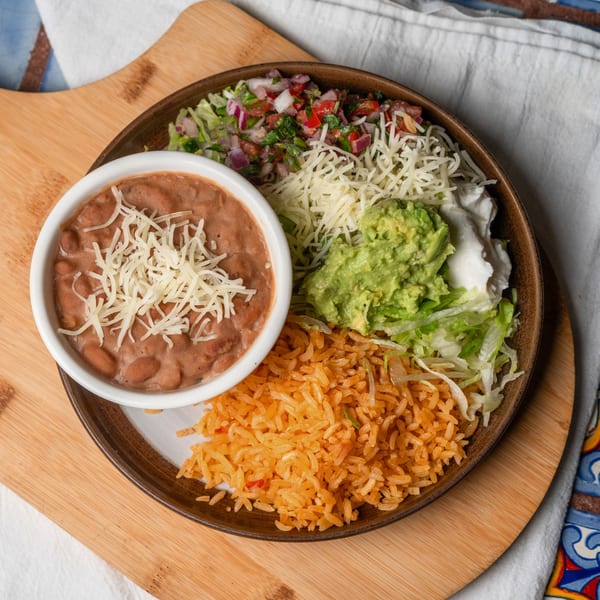 Mexican platter with refried beans, rice, guacamole, sour cream, shredded cheese, and pico de gallo.